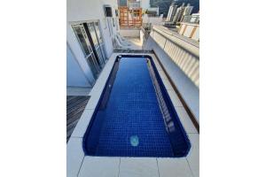 a swimming pool on the roof of a building at Cobertura Piscina Enseada Guaruja in Guarujá