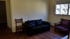 a living room with a couch and a chair at Apartamentos Enseada Guaruja in Guarujá