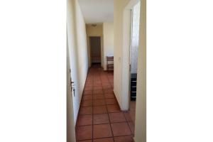 a hallway with a tile floor and white walls at Apartamentos Enseada Guaruja in Guarujá