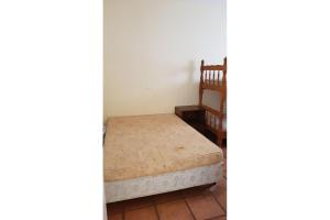 a bed sitting in a room next to a staircase at Apartamentos Enseada Guaruja in Guarujá
