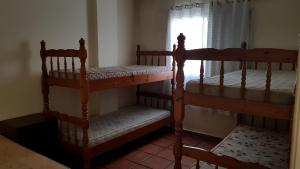 two bunk beds in a room with a window at Apartamentos Enseada Guaruja in Guarujá +20 photos