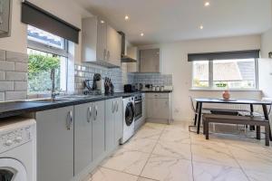 a kitchen with a sink and a table in it at 4 bed home sleeps 8 & Close to the QMC hospital in Nottingham