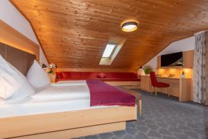 a bedroom with a large bed with a wooden ceiling at Pension Ludwig Thoma in Otterfing