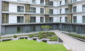 un edificio de apartamentos con un patio con bancos y césped en The Lennox Luxury Apartment, en Accra