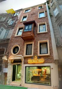 a tall brick building with a sign on it at Şiva Pera Hotel & SPA in Istanbul
