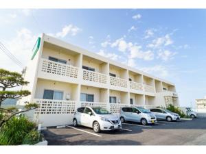 a hotel with cars parked in a parking lot at Bears Stay Kumejima Eef Beach - Vacation STAY 85666v in Kumejima
