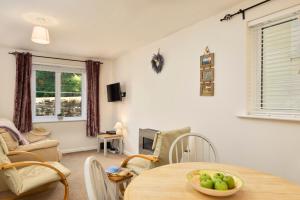 Bossell Cottage Devon في بكفاستلاي: غرفة معيشة مع طاولة وكراسي