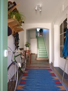 a hallway with a blue rug and a staircase with a bike at Rûte - Bed no Breakfast in Bruges