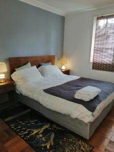 a bedroom with a large bed with two tables and a window at HOSTAL SUZI in Santiago