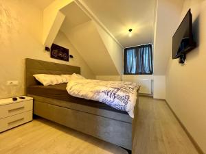 a bedroom with a bed and a tv on the wall at Lux Apartman Rudnik in Rudnik