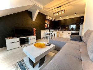un soggiorno con divano e tavolo di Lux Apartman Rudnik a Rudnik