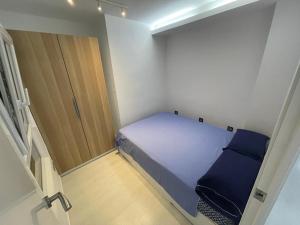 a small bedroom with a bed and a wooden door at Valencia Old Town EL CARMEN. in Valencia