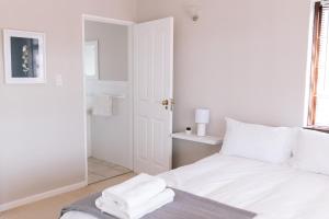 a white bedroom with a bed with towels on it at Nahoon Beach Villas Self Catering Apartments in East London +102 photos