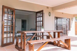 a wooden table and benches on a patio at Nahoon Beach Villas Self Catering Apartments in East London