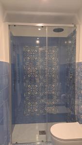 a bathroom with a glass shower with a toilet at ZiaMari in Parabita