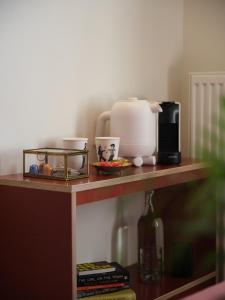a shelf with a coffee maker and cups on it at Rûte - Bed no Breakfast in Bruges
