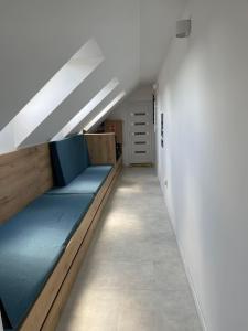 um quarto com um longo sofá azul num quarto em Fenyves Beach Apartman em Balatonfenyves