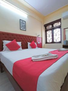 - une chambre avec un grand lit et une couverture rouge dans l'établissement Sanman Hotels, à Vasco Da Gama