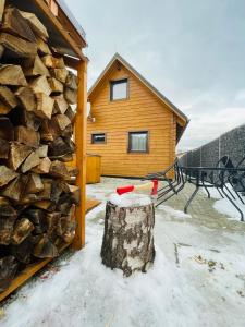 uma cabana de madeira com uma pilha de lenha em Rezortík Lučivná pre rodiny s deťmi, 300m od vleku, Vysoké Tatry em Lučivná