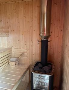 a wood fired stove in a wooden cabin with a bucket at Rezortík Lučivná pre rodiny s deťmi, 300m od vleku, Vysoké Tatry in Lučivná