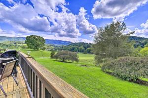 a deck with a view of a field and trees at Secluded Mountain City Home with Deck and Views! in Mountain City