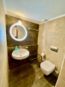 a bathroom with a sink and a toilet and a mirror at Υπέροχη οικογενειακή κατοικία στον Πειραιά, 3 λεπτά από μετρό in Piraeus