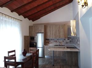 une cuisine avec des placards en bois et une table avec des chaises dans l'établissement Apartamentos turísticos Cambil, à Cambil