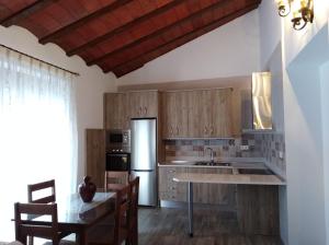a kitchen with wooden cabinets and a table with chairs at Apartamentos turísticos Cambil in Cambil