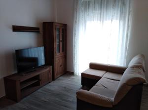 a living room with a couch and a flat screen tv at Apartamentos turísticos Cambil in Cambil
