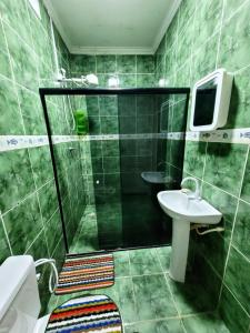 een badkamer met een douche, een toilet en een wastafel bij House Maraca in Ipojuca