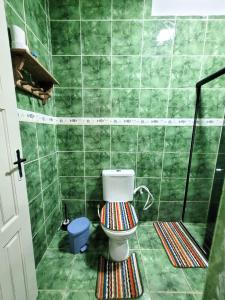 House Maraca في إيبوجوكا: حمام أخضر مع مرحاض وفرش أرضية مخططة