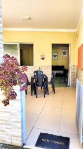 een patio met een tafel en stoelen en een piano bij House Maraca in Ipojuca