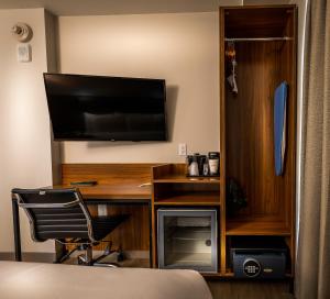 a bedroom with a desk with a television and a chair at La Quinta by Wyndham Time Square South in New York