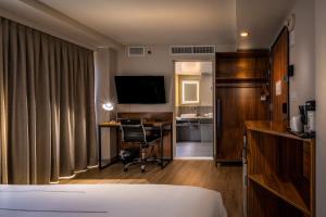 een hotelkamer met een bed, een bureau en een televisie bij La Quinta by Wyndham Time Square South in New York