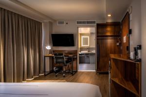 a hotel room with a bed and a desk and a television at La Quinta by Wyndham Time Square South in New York
