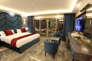 a bedroom with a bed and a desk and a television at Petra Sella Hotel in Wadi Musa