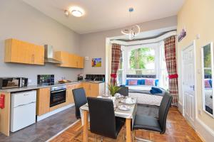 cocina y comedor con mesa y sillas en The Elm Wood Apartments, en Huddersfield