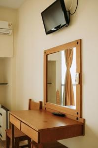 a mirror on a wall with a wooden table at Olympia Hotel in Lorena