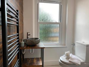 La salle de bains est pourvue d'un lavabo et d'une fenêtre. dans l'établissement De Parys Serviced Flat in Bedford 4, à Bedford