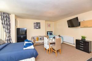 a bedroom with a bed and a living room at The Elm Wood Apartments in Huddersfield
