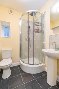 a bathroom with a shower and a toilet and a sink at The Elm Wood Apartments in Huddersfield