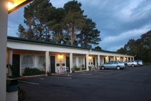 a building with cars parked in a parking lot at The Tree Motel in Narooma