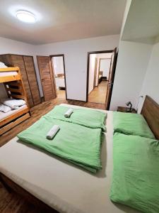 a bedroom with two green blankets on a bed at Horský Dům Horalka in Železná Ruda