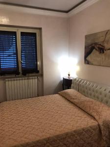ein Schlafzimmer mit einem Bett und zwei Fenstern in der Unterkunft B&B Villa Pina in Colleferro