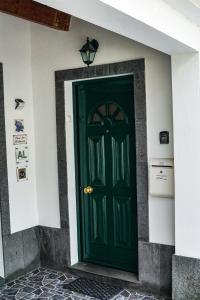 una puerta verde al lado de un edificio en Casa das Hortênsias, en Ponta Delgada