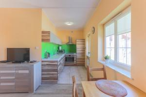 a kitchen with green cabinets and a dining table at Apartament Gdańsk Stare Miasto przy Neptunie in Gdańsk