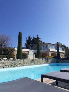 a large swimming pool with a house in the background at Bastidon Plein Sud in Gordes