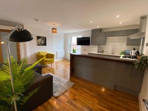 een keuken en een woonkamer met een bank en een tafel bij De Parys Penthouse 5 in Bedford in Bedford