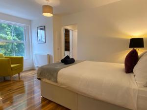 een slaapkamer met een bed, een stoel en een raam bij De Parys Penthouse 5 in Bedford in Bedford
