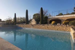 a swimming pool in front of a stone wall at Bastidon Plein Sud in Gordes +33 photos